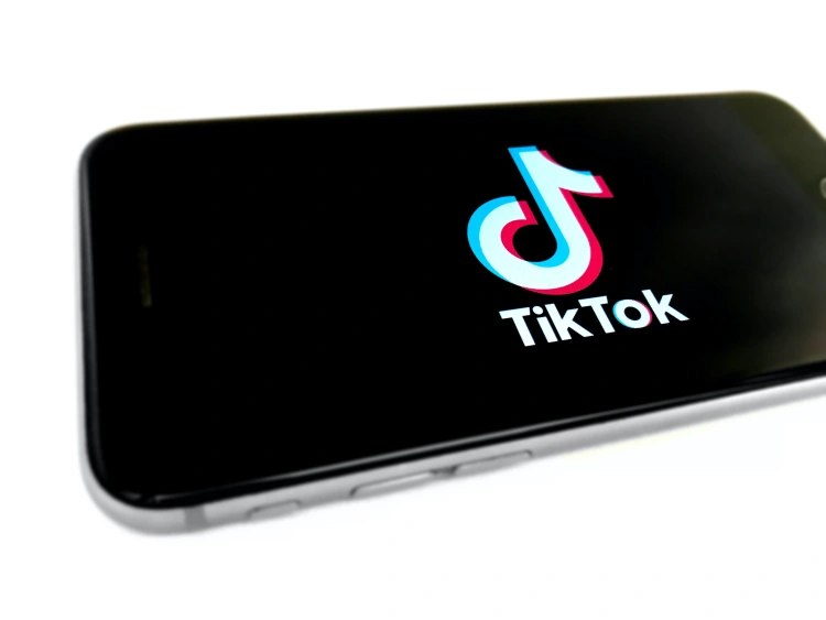 Logo TikToka na smartfonie na białym tle.