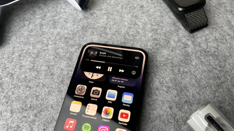 iPhone 14 Pro w kolorze czarnym na szarym tle.